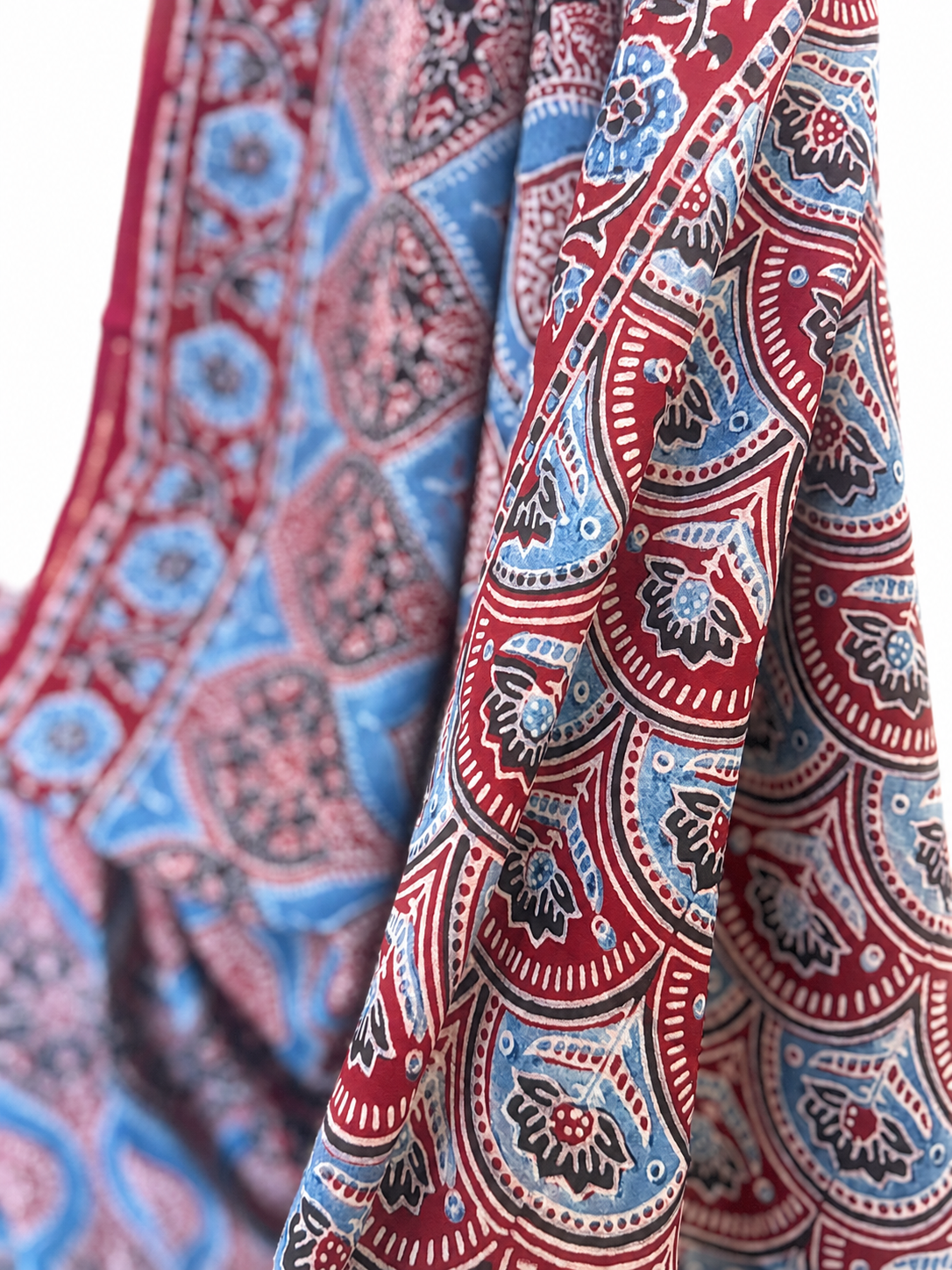 Close-up of indigo and maroon Ajrakh hand block print Modal silk saree featuring intricate traditional paisley motifs in red, blue, black and beige tones
