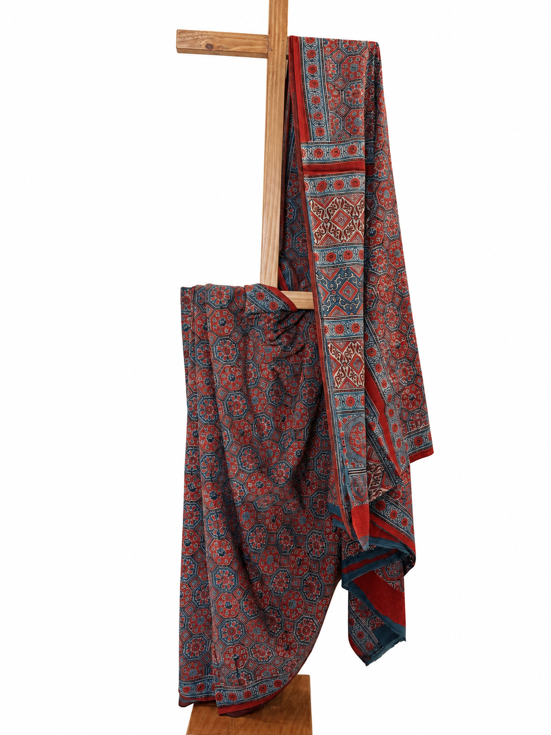 Red and indigo Ajrakh hand block print Mal Mal cotton saree featuring intricate traditional floral and geometric motifs with a decorative red border, displayed on a wooden stand